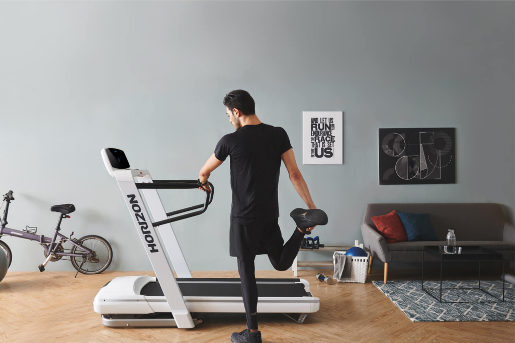 Sportler wärmt sich vor dem Training auf einem Laufband auf – einer der häufigsten Fitnessfehler ist fehlendes Aufwärmen vor dem Kraft- und Ausdauertraining