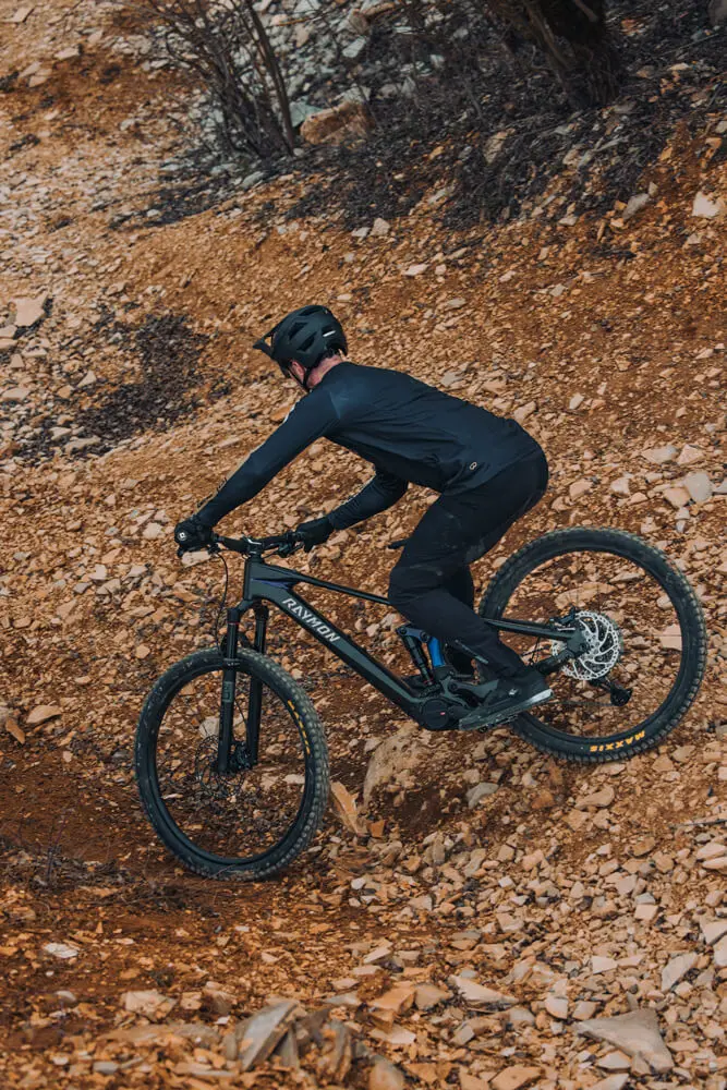 Der neue Avinox M2S E-Bike Motor im Raymon Tarok Ultra.
Im gezeigten Bild fährt der Fahrer mit dem E-Bike einen Trail runter und zeigt den Einsatzzweck des neuen E-Bike Antriebs