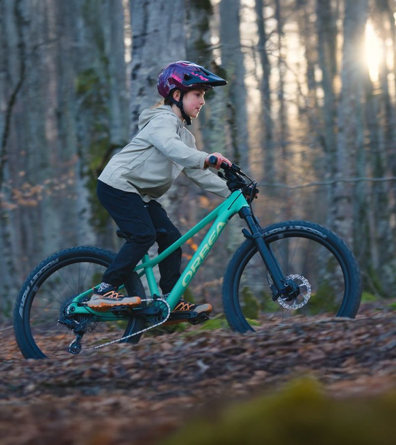 Das Orbea Kimu 24 Kinderfahrrad. Das Kindermountainbike für Kinder im Alter von 7 bis 10 Jahren. Die 3 Kinder Bike Modelle.
Im Bild fährt ein junges Mädchen mit den neuen Orbea Kimu 24 im Wald.