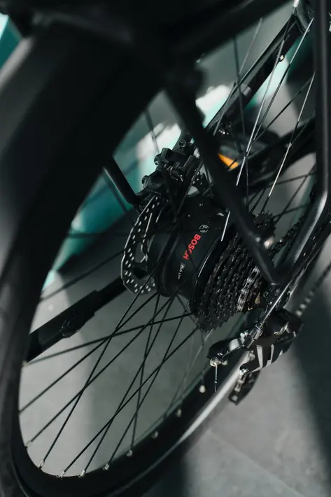 Detailaufnahme des neuen Bosch Hub Line Nabenmotors im Hinterrad eines E-Bikes. Sichtbar sind der elektrische Antrieb, die Kassette, das Schaltwerk und die Scheibenbremse – moderne Bosch E-Bike-Technologie für City-, Trekking- und Alltagsräder.