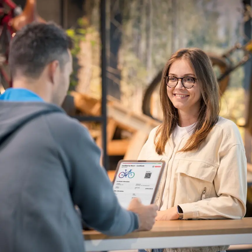 Kundin erhält im Fahrradgeschäft ein ‚Certified by Bosch‘ Zustand-Zertifikat für ein E-Bike, sorgt für Transparenz, Vertrauen und geprüfte Qualität beim E-Bike-Kauf