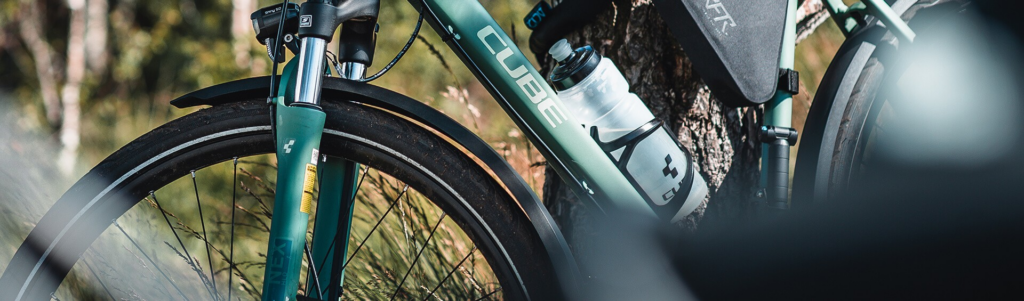 Nahaufnahme eines Cube Trekking- oder Bikepacking-Fahrrads mit Trinkflasche, Rahmentasche und Schutzblechen – praktische Ausstattung für lange Radtouren.