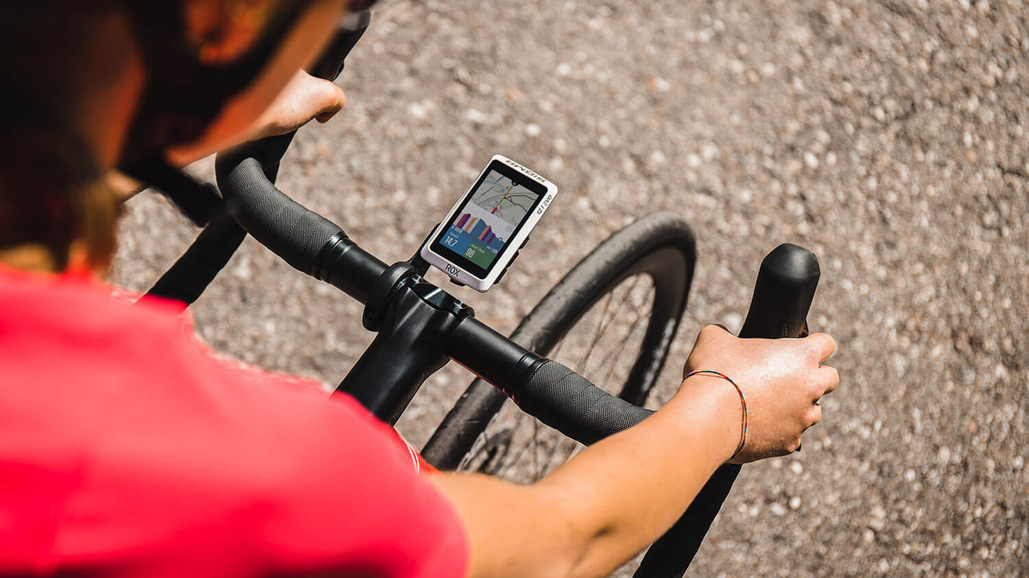 Radfahrer nutzt einen GPS-Fahrradcomputer mit Navigation am Rennradlenker – ideal für Bikepacking-Touren, Routenplanung und Trainingsauswertung.